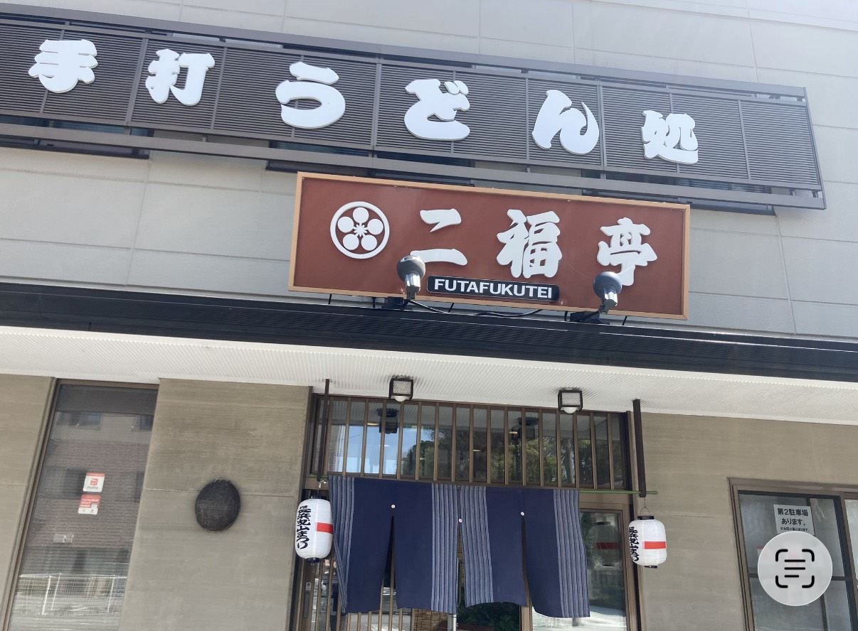 「手打うどん処」の文字と二福亭の看板が掲げられた店舗の外観