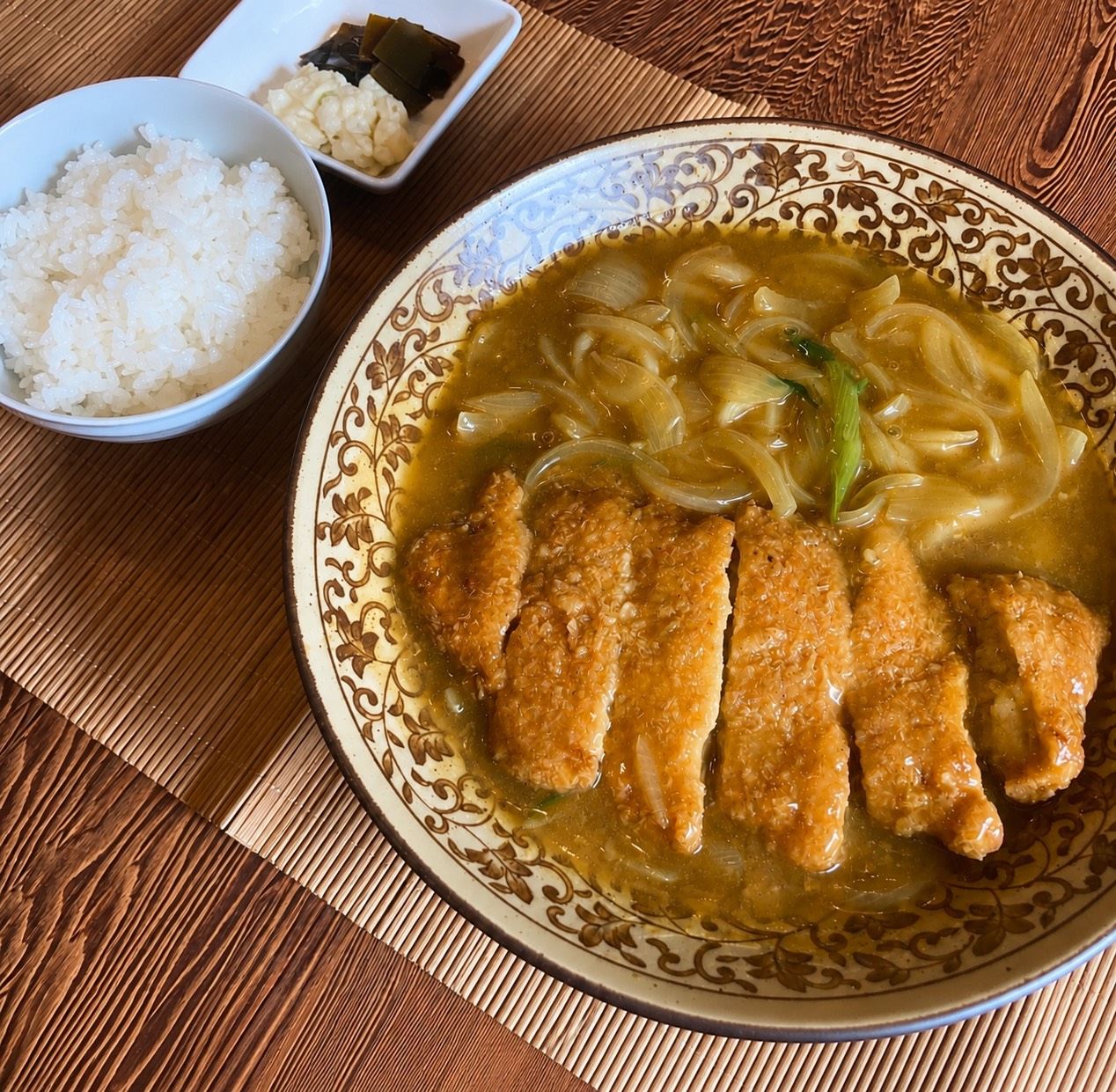 カツにカレーのおつゆと玉ねぎをたっぷりかけた一皿と、ごはん・お漬物