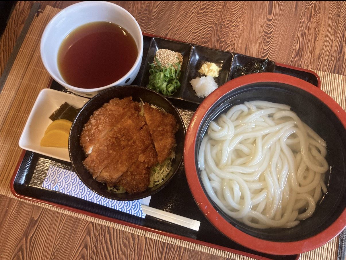 カツをのせた丼と、釜揚げうどん、薬味がそろったお膳